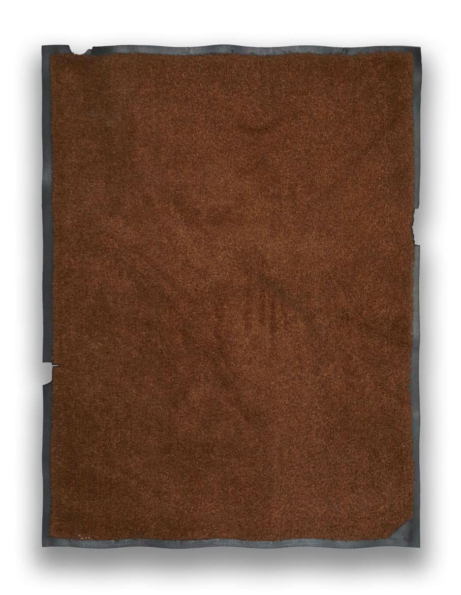 A walk-off mat with a damaged, frayed border before repair